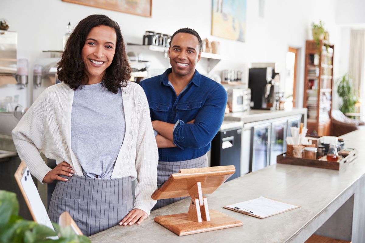 Small business owners behind the counter of their shop